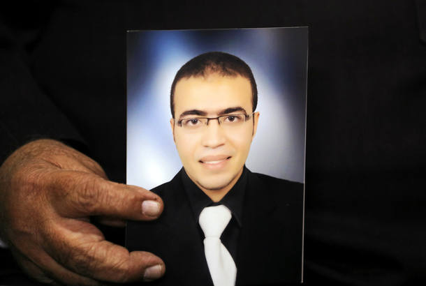 Reda Abdullah al-Hamamy, the father of Abdullah Reda al-Hamamy who is suspected of attacking a soldier in Paris' Louvre museum, holds picture of son during an interview with Reuters in Daqahliya